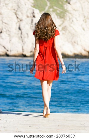stock photo young girl in red dress on the sea