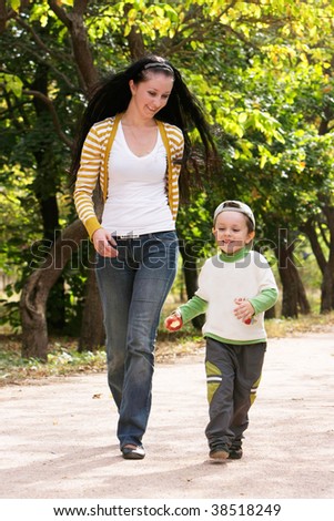 mother and son running in autumn park