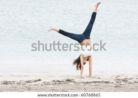 young girl doing gymnastics on beach