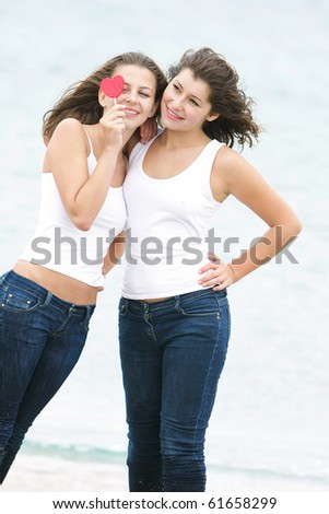 two girls with heart-shaped candy on natural background