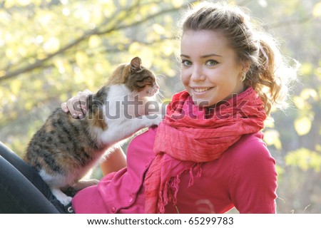 attractive girl with cat on natural background