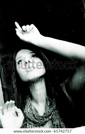 sad young girl behind wet window