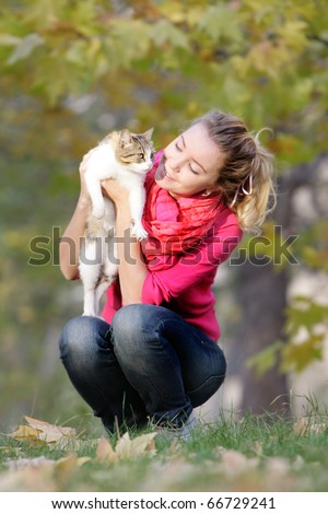 young girl with cat on natural background