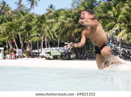 happy boy jumping in water
