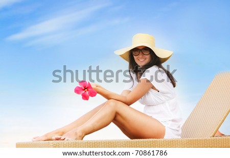 young beautiful woman relaxing isolated on sky background