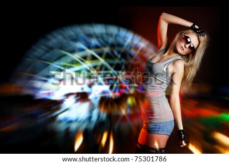 young beautiful woman dancing on nightclub background