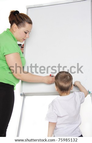 teacher and young boy next to white board