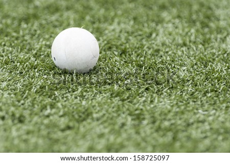 Lacrosse ball isolated on artificial turf with shallow depth of field and copy space
