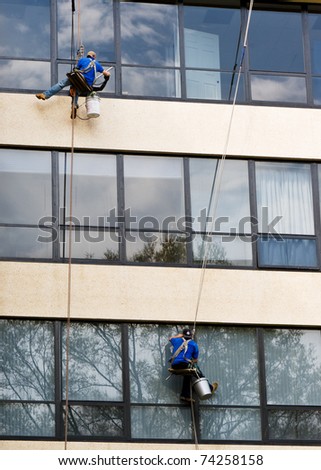 Two men washing windows in a high-rise