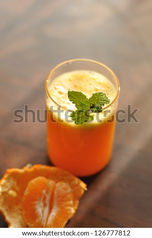 Orange juice in a glass with mint leaves and cut orange