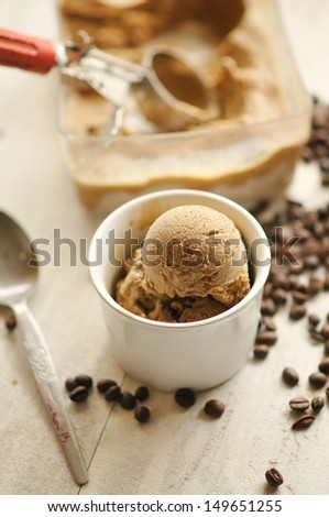 Coffee ice cream with scoop with coffee beans in the background