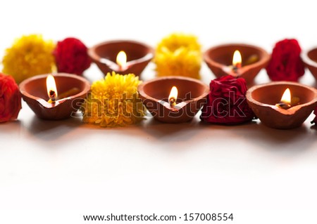 Diwali Diyas in a row on a isolated white background with flowers or floral decorations Diwali Diyas in a row on a isolated white background with flowers or floral decorations