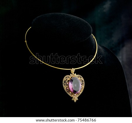 Luxury golden necklace with purple gemstone pendant decorated by gold