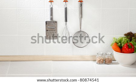 Kitchen cooking utensils on hook against tile wall