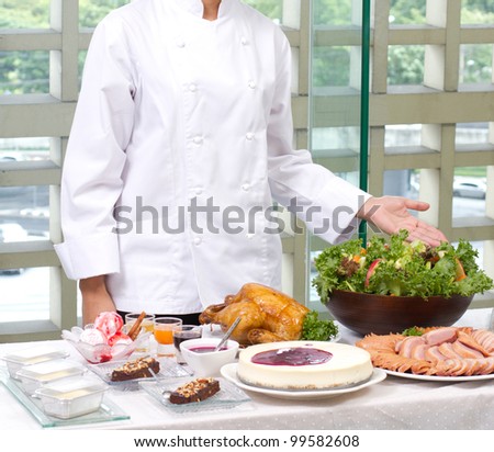 Female chef showing a lot of cooked food and bakery