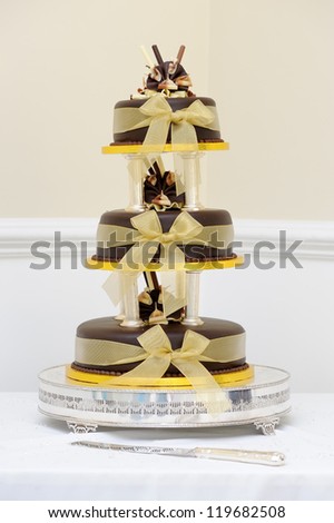 Chocolate wedding cake with gold decoration at reception
