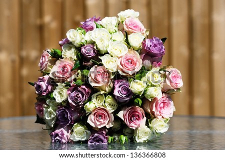 Closeup of brides flowers on wedding day are pink and purple roses