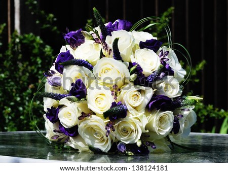 Brides arrangement of purple flowers and white roses on wedding day