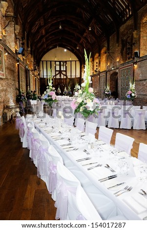 Wedding reception table decoration showing flower arrangement and silver cutlery
