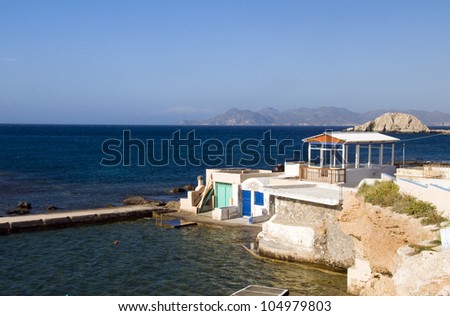 fisherman houses built into rock cliffs on Mediterranean Sea Firopotamos Milos Cyclades Greek Island Greece