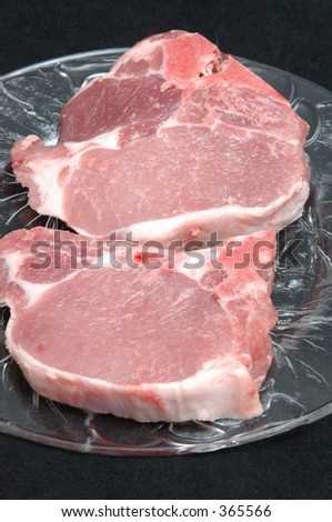 two center cut pork chops on a clear plate