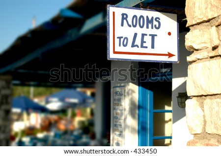 rooms to let sign in the greek islands with the background photographed intentionally  out of focus