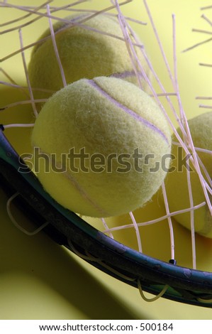 broken strings on yellow background with tennis balls
