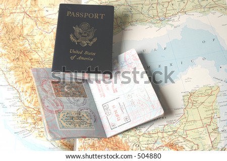 two passports on an atlas opened to the americas