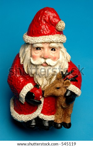 wide eyed smiling santa claus feeding one of the reindeer