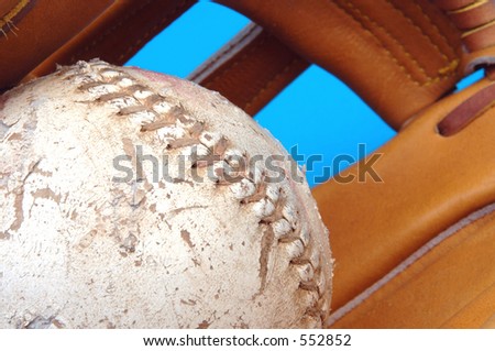 focus on a well worn softball with a fade into a baseball glove
