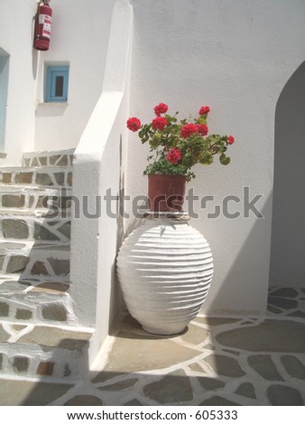 large ceramic vase with geraniums in greek islands