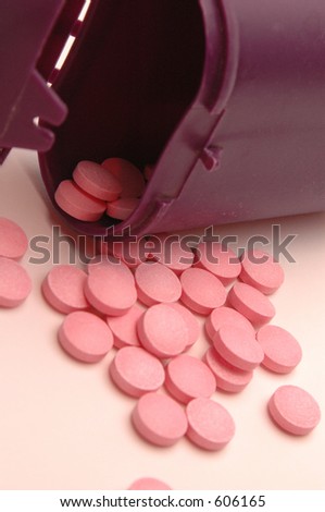 vitamin pills with focus on pills directly under body of the bottle to draw the eye in