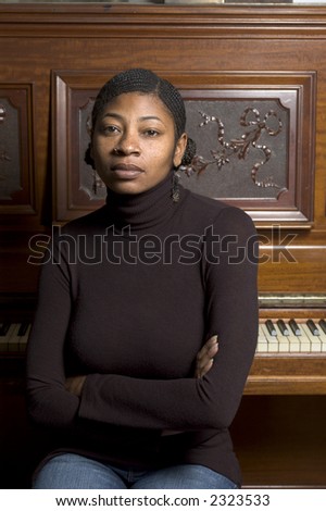 pretty black woman at piano with braided hair and nose ring