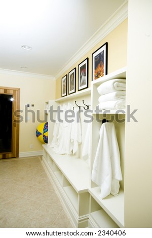bathrobes towels hanging in a custom locker room with sauna entry