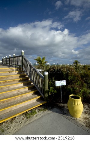 don\'t walk barefoot sign  boardwalk yellow urn by the beach caribbean sea