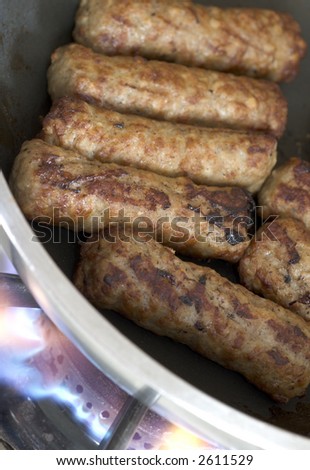 low fat turkey and pork sausages cooking in frying pan on the range