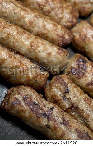 low fat turkey and pork sausages cooking in frying pan on the range
