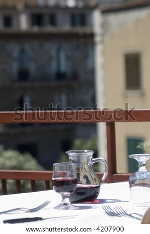taormina italy restaurant table with carafe red wine  with view of town