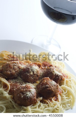 spaghetti and meatballs classic with cheese parmesan glass of red wine