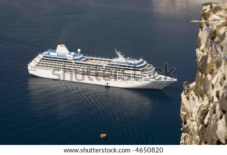 passenger cruise ship greek island harbor with volcanic caldera cliff