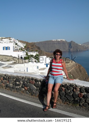 middle age female lady tourist smiling romantic hotel view traditional house with volcanic cliff caldera view greek islands greece santorini thira ia oia town
