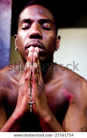 handsome black african american actor on theater stage acting preacher reverend praying with cross