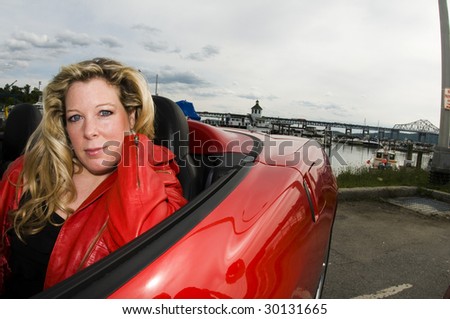 sexy woman with red sports car by a yacht club on the hudson river new york