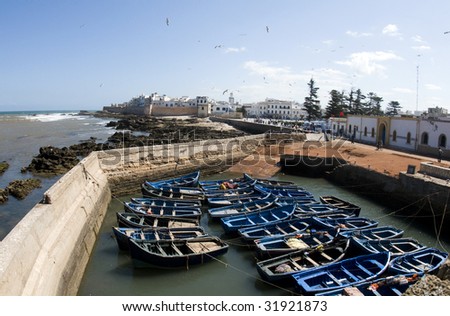 view of fishing boats in harbor and old city medina with ramparts and the skala de la ville essaouira mogador morocco in africa