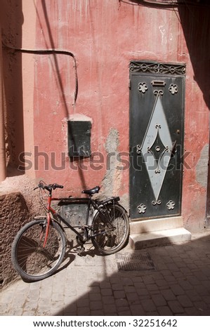 back alley street scene in old medina shopping district of casablanca morocco with detail door architecture and old bicycle