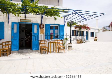 outdoor cafe setting with typical greek furniture chairs and generic architecture in the greek islands village of lefkes paros cyclades island greece