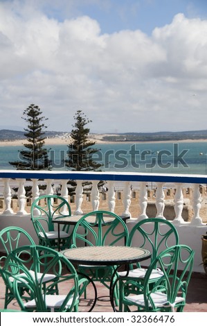 essaouira morocco rooftop view of hotel deck with tables chairs overlooking tourist beach