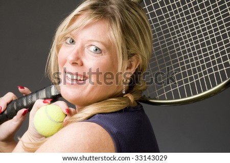 happy smiling middle age woman tennis player with racquet and ball