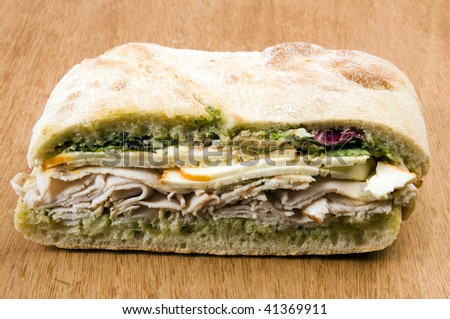 gourmet ovengold roast turkey sandwich with muenster cheese sliced avocado spring mix pesto mayonaisse on ciabatta bread