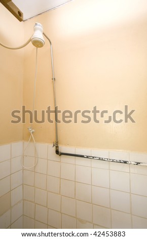 typical simple shared shower room bathroom in budget caribbean west indies guest house with hot water head attached